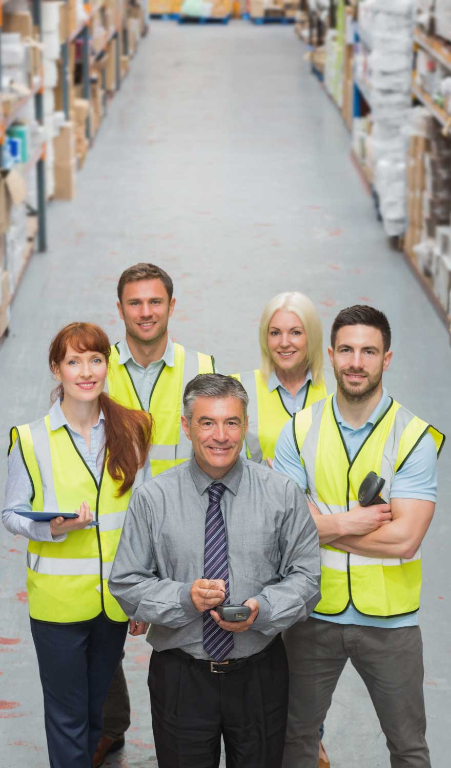 temp agencies in New Castle workforce placement showing warehouse staff and a supervisor in safety vests standing together in an industrial storage aisle, representing staffing support and employment solutions.